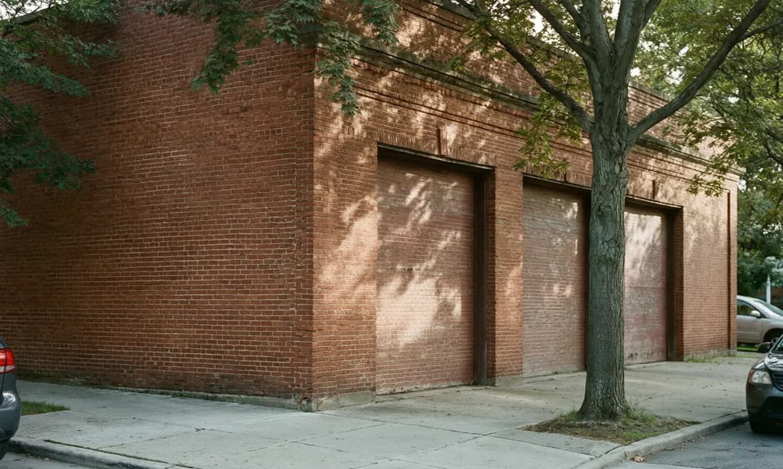 The brick corner of an old fire station on an ordinary residential street.
